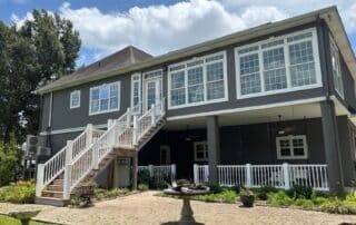 Large modern house exterior painted dark gray with bright white trim and an outdoor staircase. Exterior Paint Sheen
