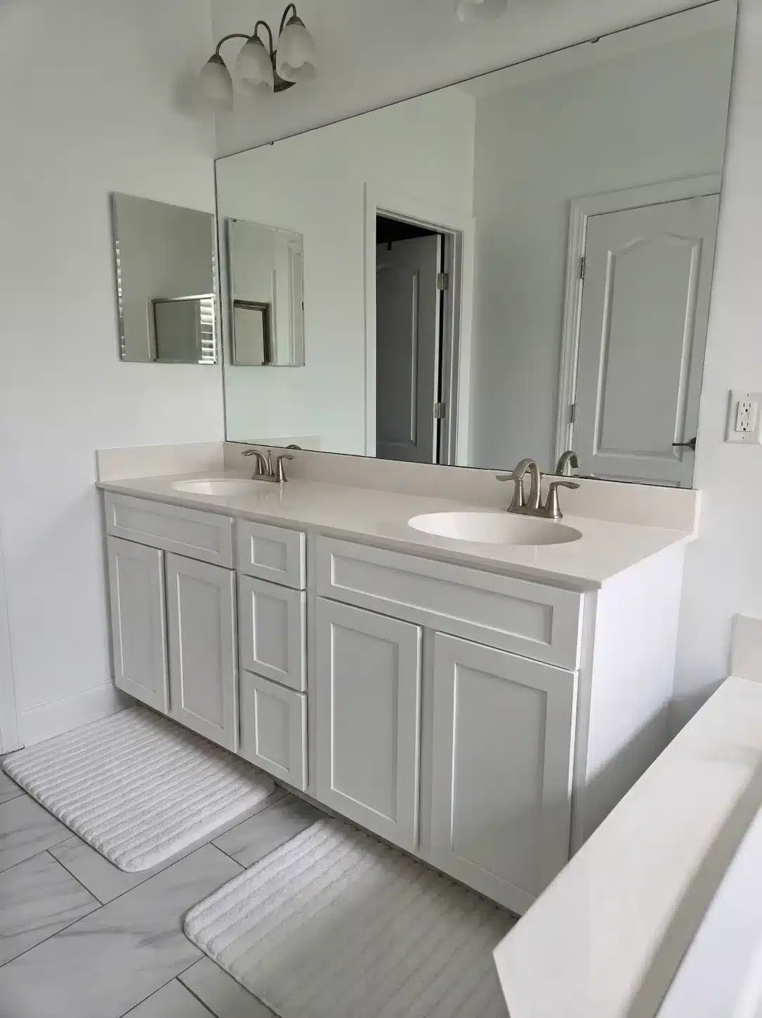 Cream Painted Bathroom Vanity Cabinets Cream-painted dual-sink bathroom vanity with recessed panel cabinet doors, brushed nickel faucets, and quartz countertop.