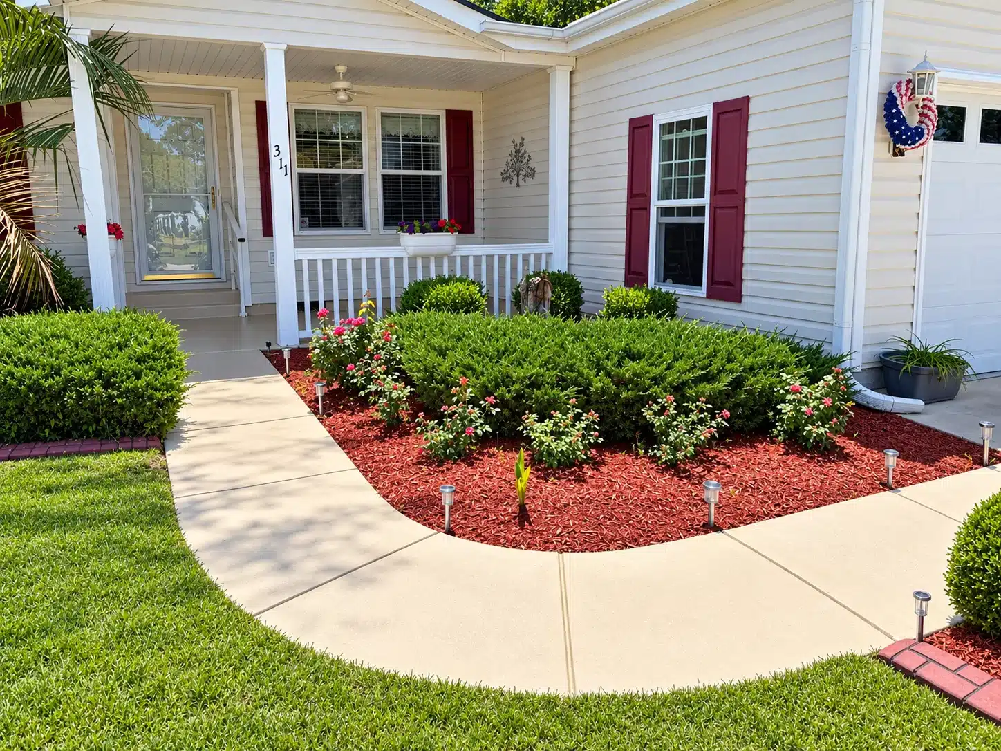 Burgundy Shutters White Trim Home Light gray vinyl-sided home with white-painted trim, columns, burgundy shutters, and wrap-around porch in North Myrtle Beach.