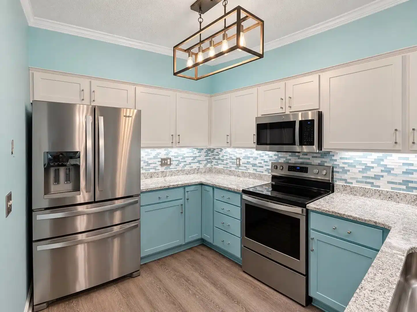 Two-Tone Kitchen Cabinetry Painting Two-tone kitchen with cream upper cabinetry, turquoise lower cabinetry, blue-gray tile backsplash, light granite