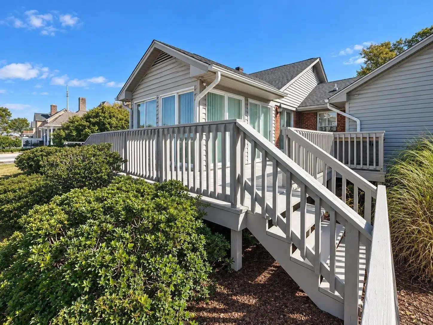 White Painted Deck Railing White-painted deck railing with vertical balusters on two-story residential home with light gray vinyl siding in North